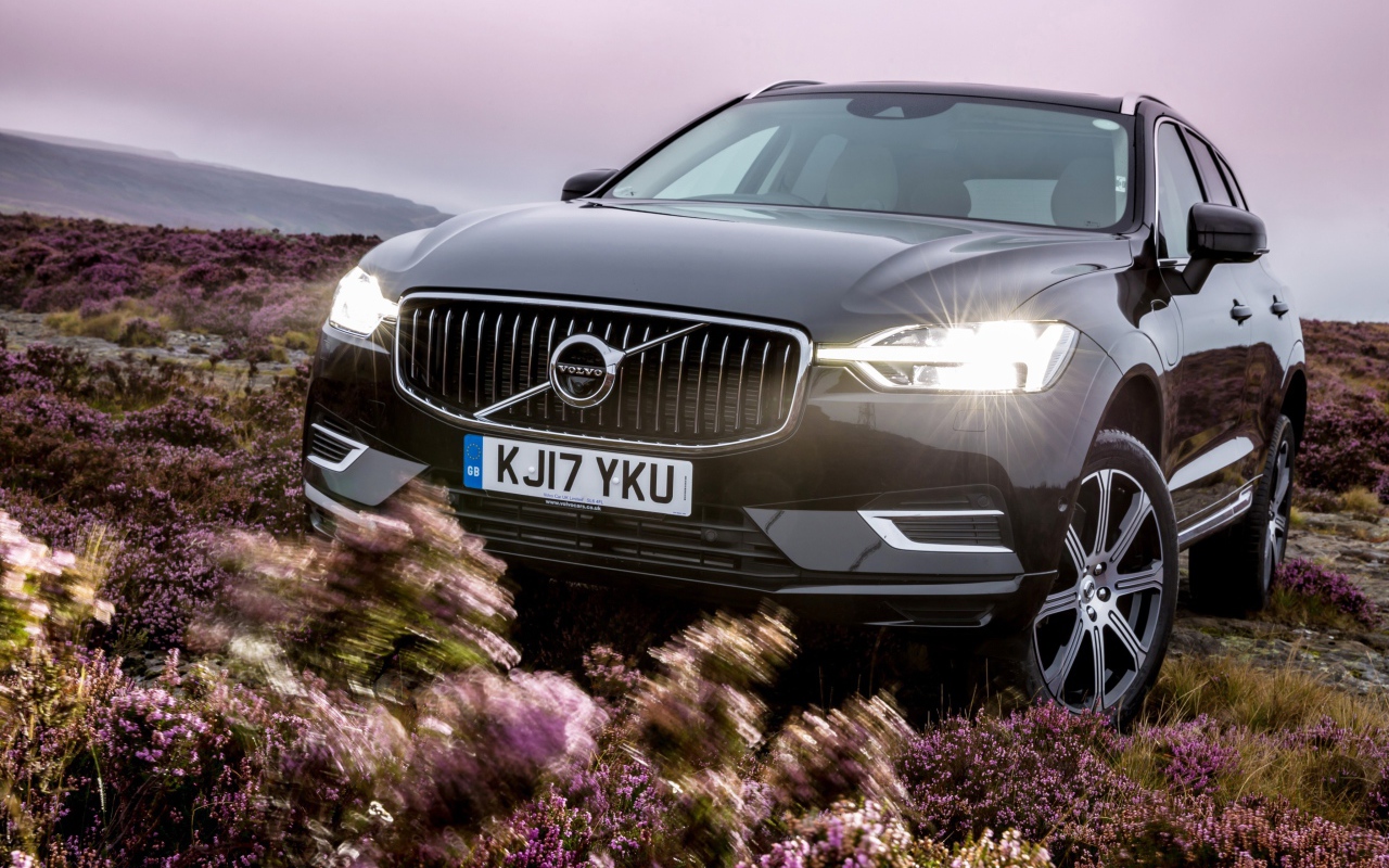 Черный автомобиль Volvo XC60 T8, 2018 с включенными фарами