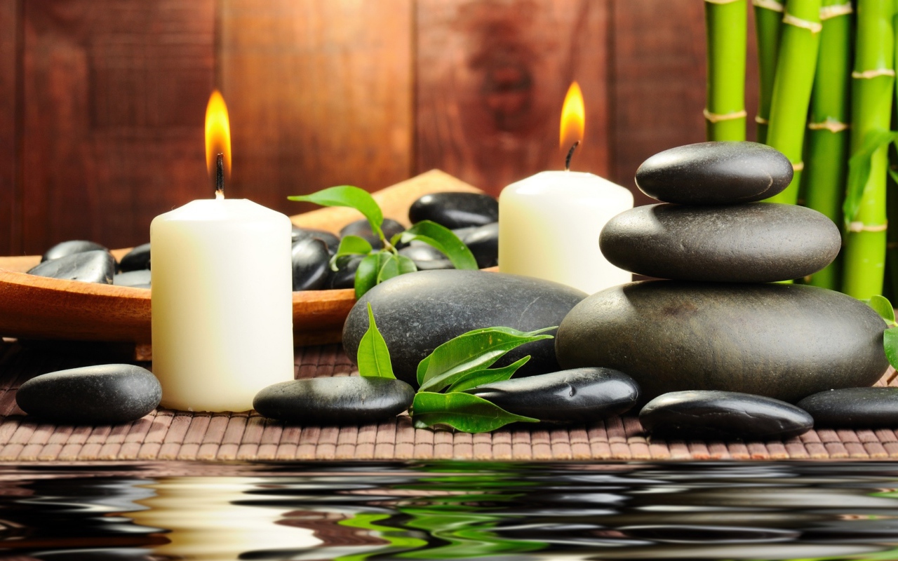 Черные камни дзен с двумя горящими свечами