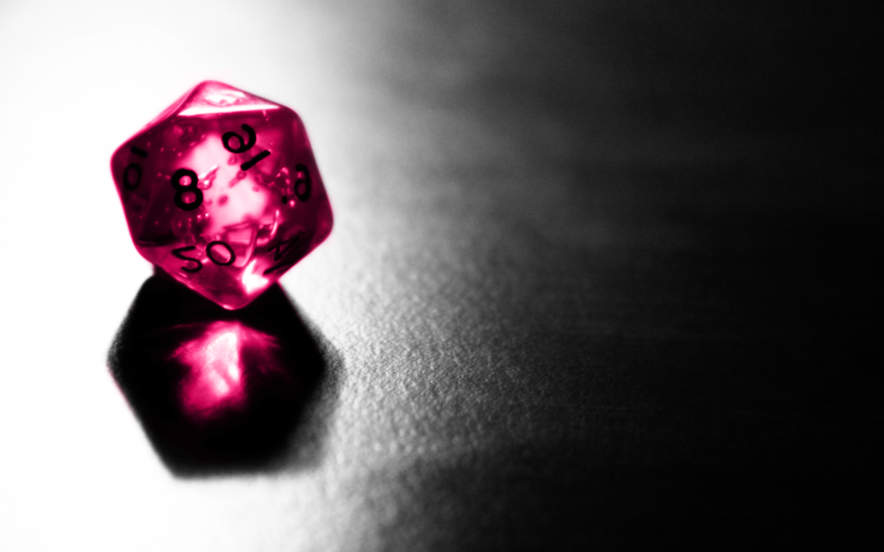 Розовый фигурный кубик отражается серой поверхности стола