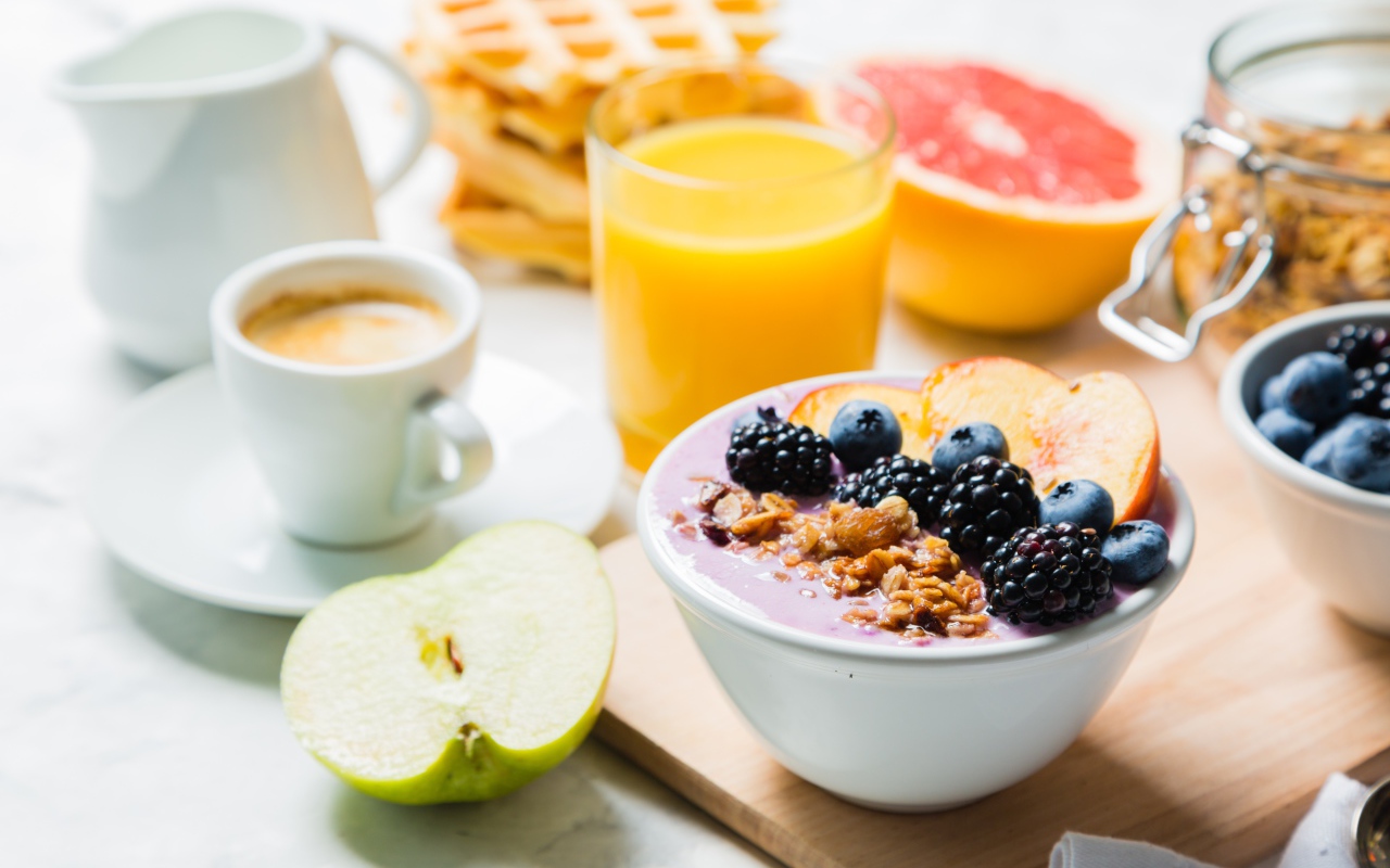 Завтрак с овсянкой, ягодами, фруктами и свежим соком на столе