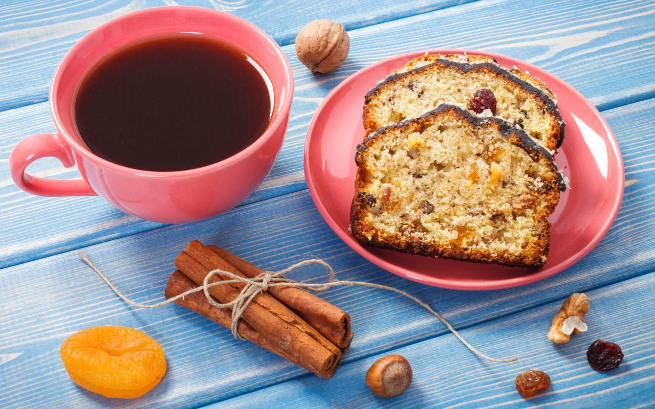 Кекс с корицей, орехами и курагой на столе с чашкой чая
