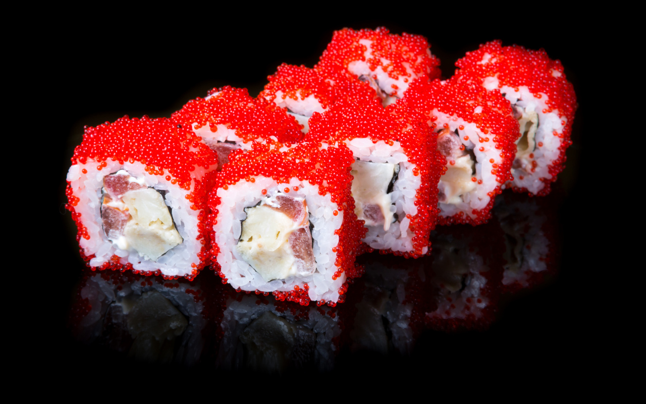 Японские роллы с красной икрой на черном фоне 