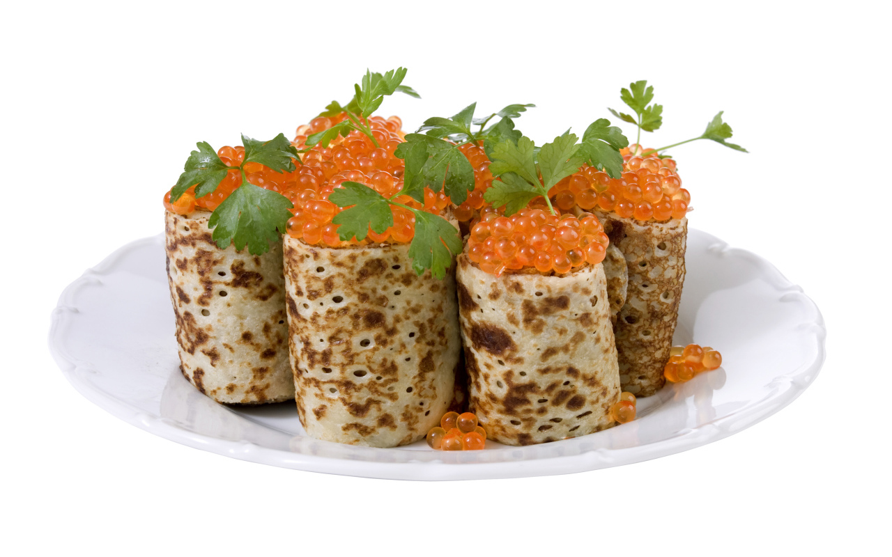 Роллы из блинов с красной икрой на белом блюде