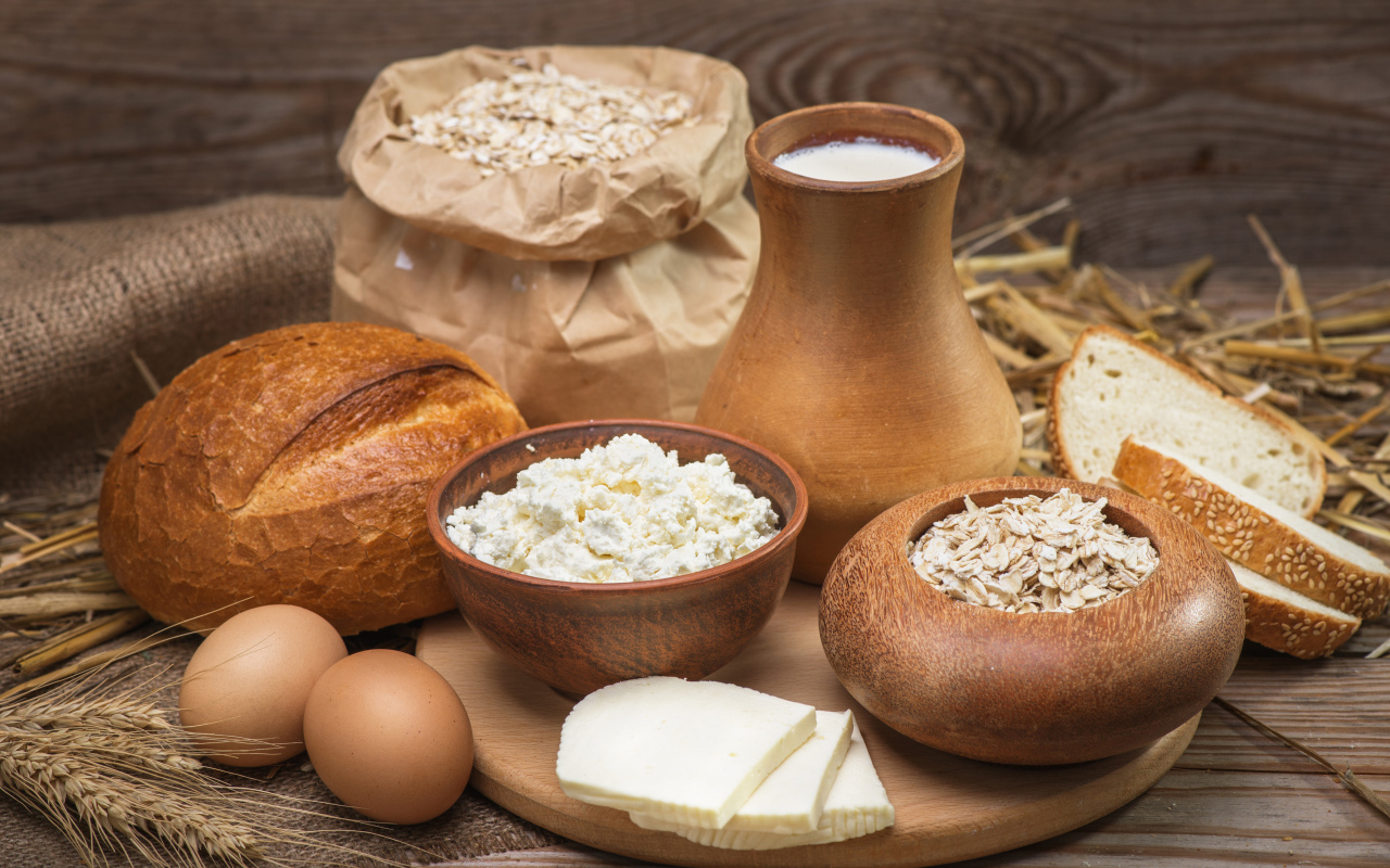 Натюрморт сыр, хлеб, яйца и молоко на столе 