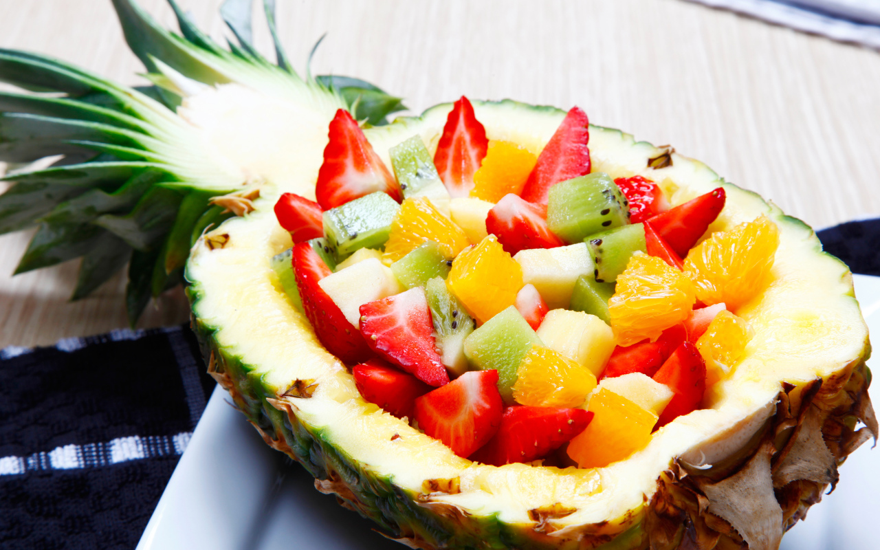 Фруктовый салат из цитрусовых  в тарелке из свежего ананаса 