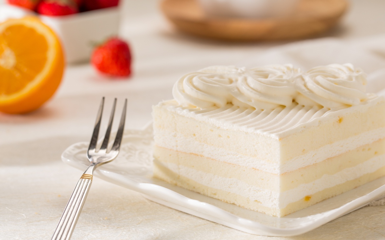 Аппетитный кусок бисквитного торта со сливочным кремом