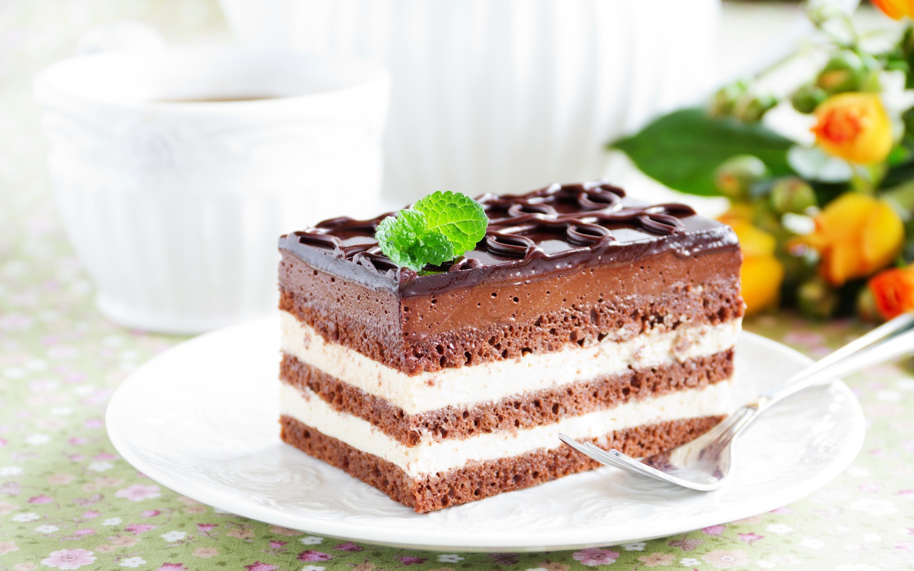 Пирожное с шоколадным и сливочным кремом на белой тарелке