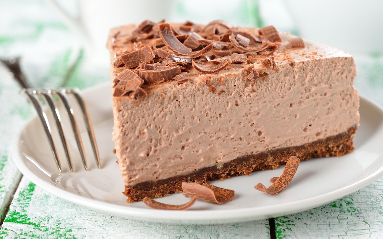 Торт с суфле и шоколадной стружкой на белой тарелке с вилкой