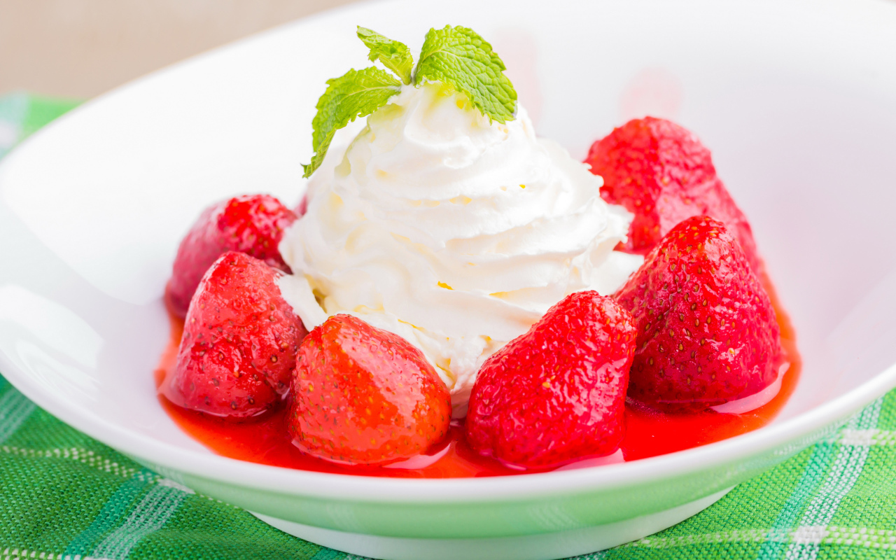 Вкусные сливки с клубникой на белой тарелке