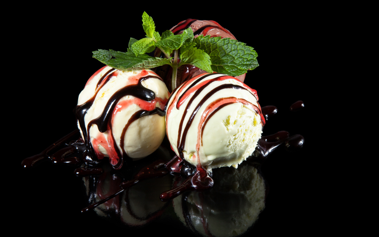 Три шарика мороженого с джемом на черном фоне