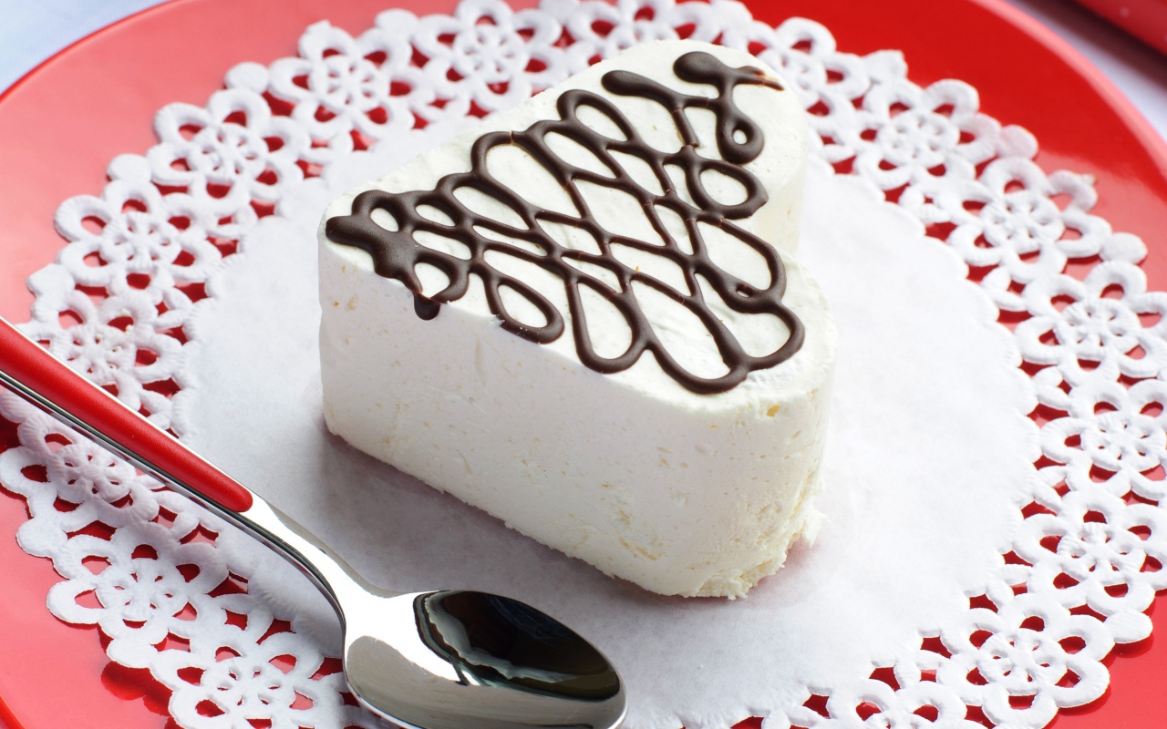 Белое пирожное в форме сердца с шоколадом