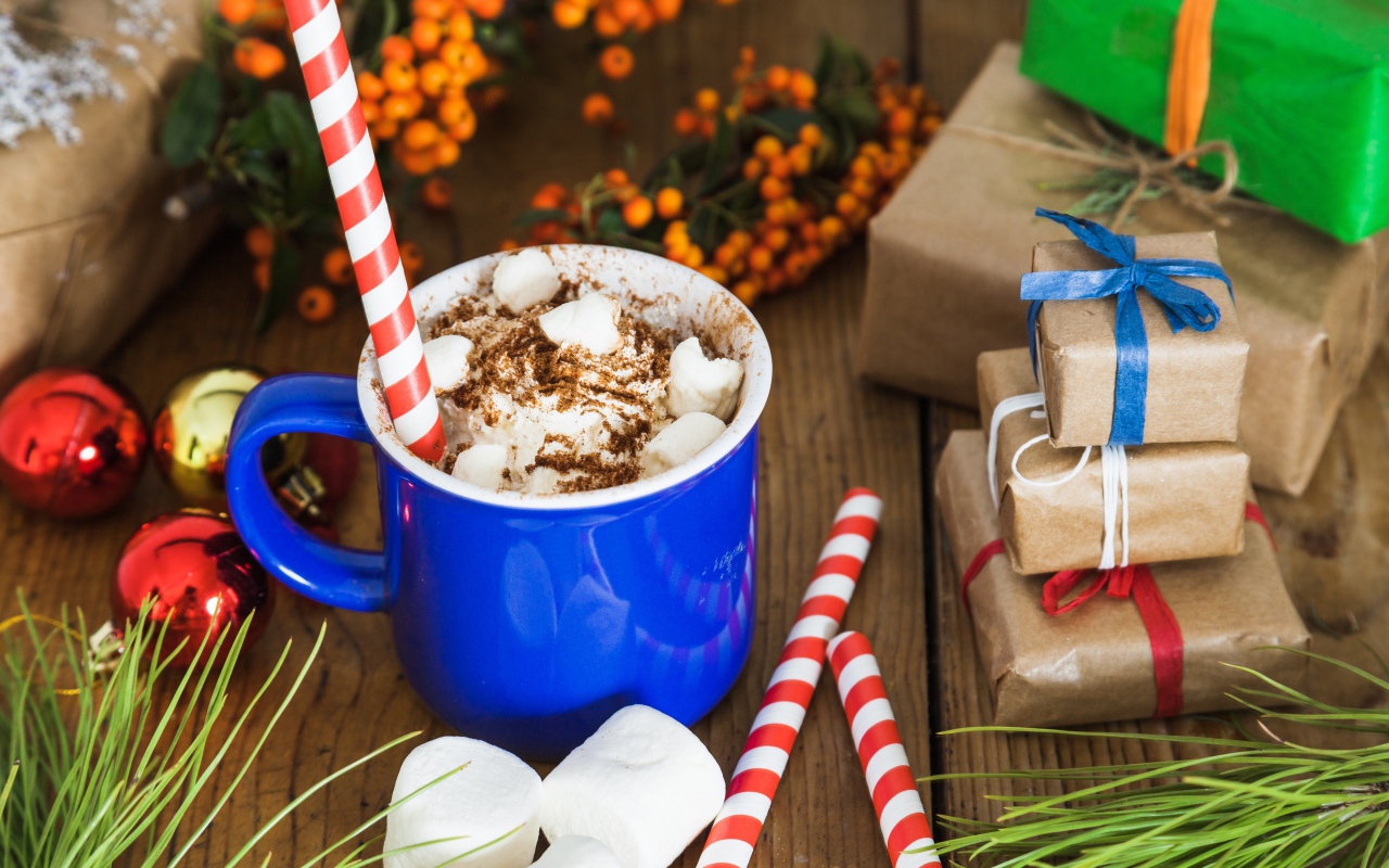 Сладкий напиток с маршмеллоу на столе с подарками на Новый год