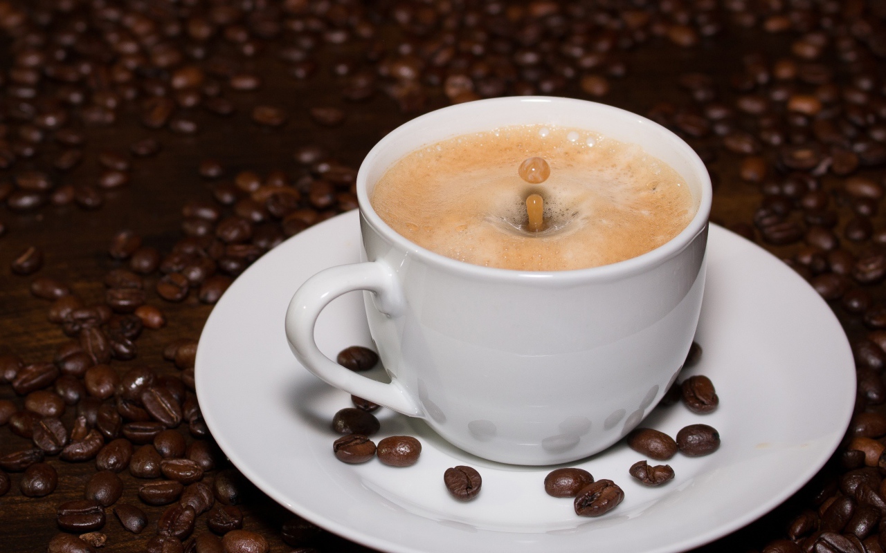 Белая большая чашка кофе с зернами на столе