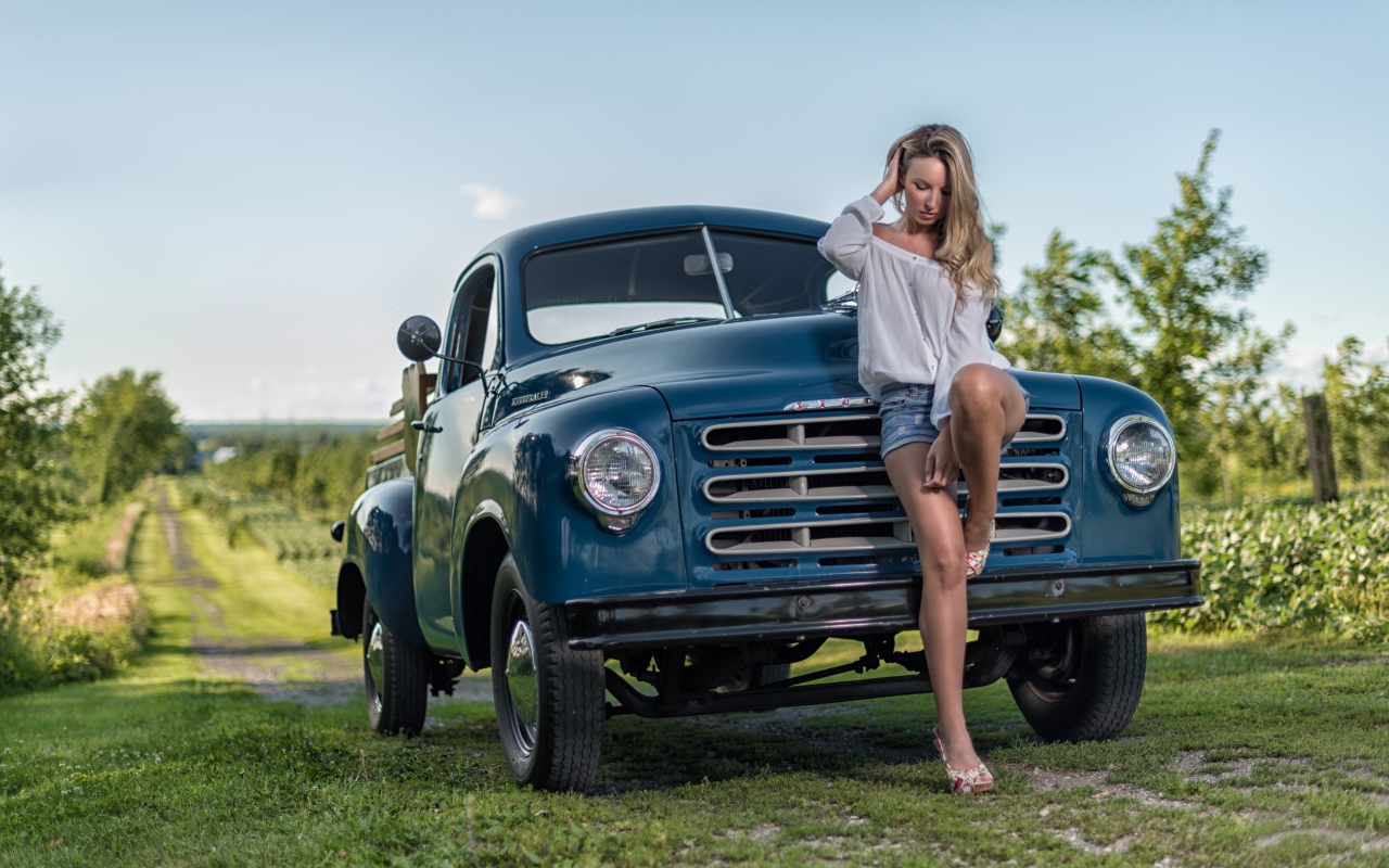 Молодая девушка стоит рядом с зеленым автомобилем Studebaker Pickup, 1953 года