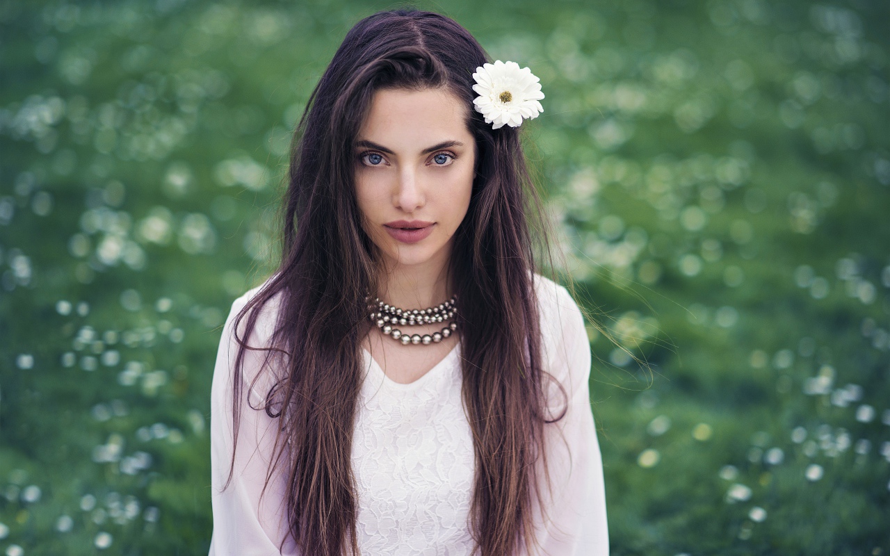 Красивая голубоглазая брюнетка с белым цветком в волосах
