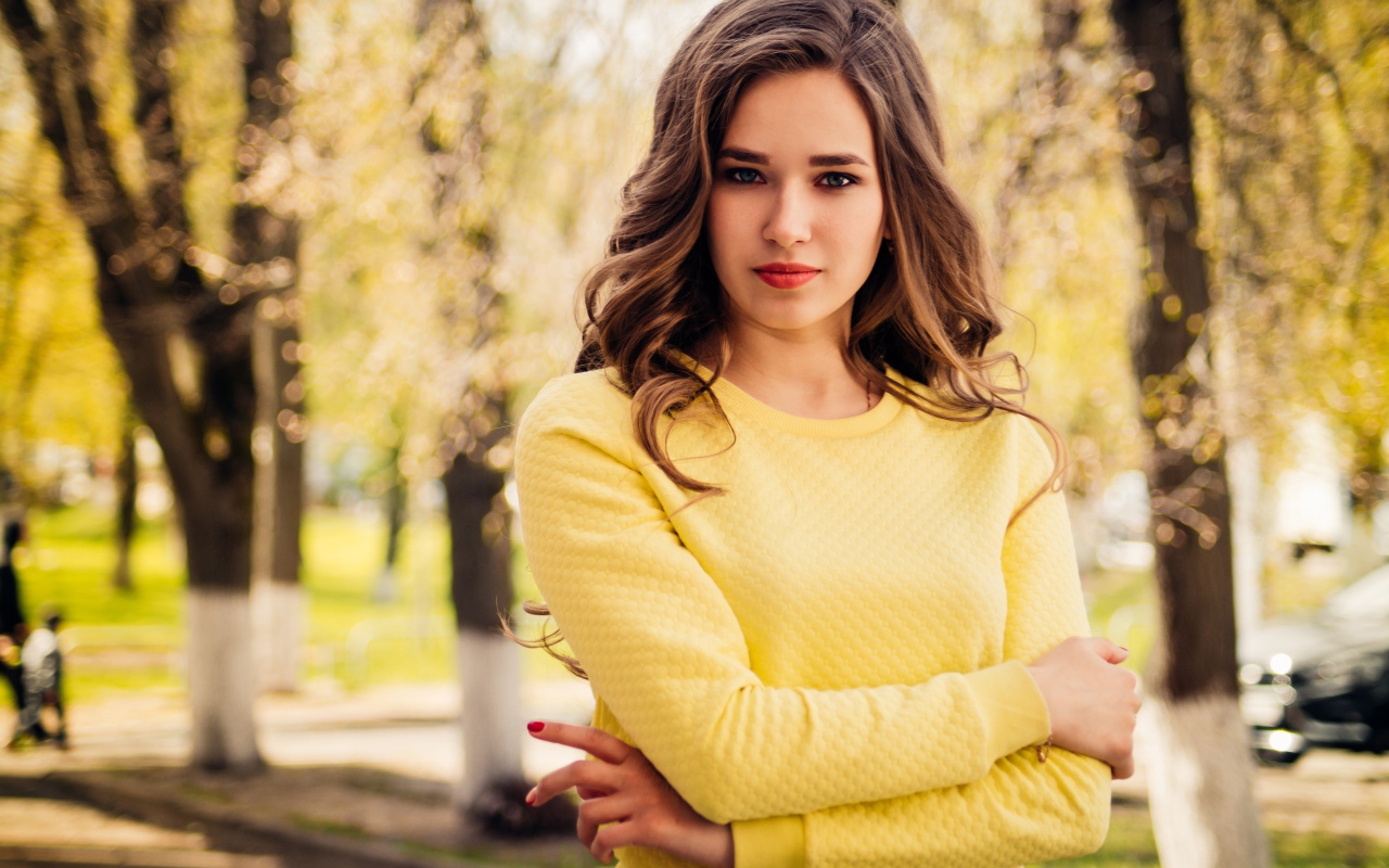 Красивая молодая голубоглазая девушка в желтом свитере
