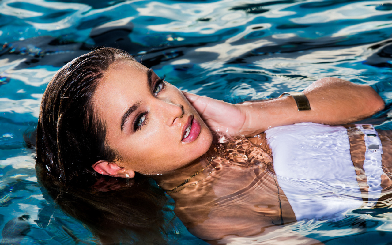 Красивая молодая девушка купается в чистой воде