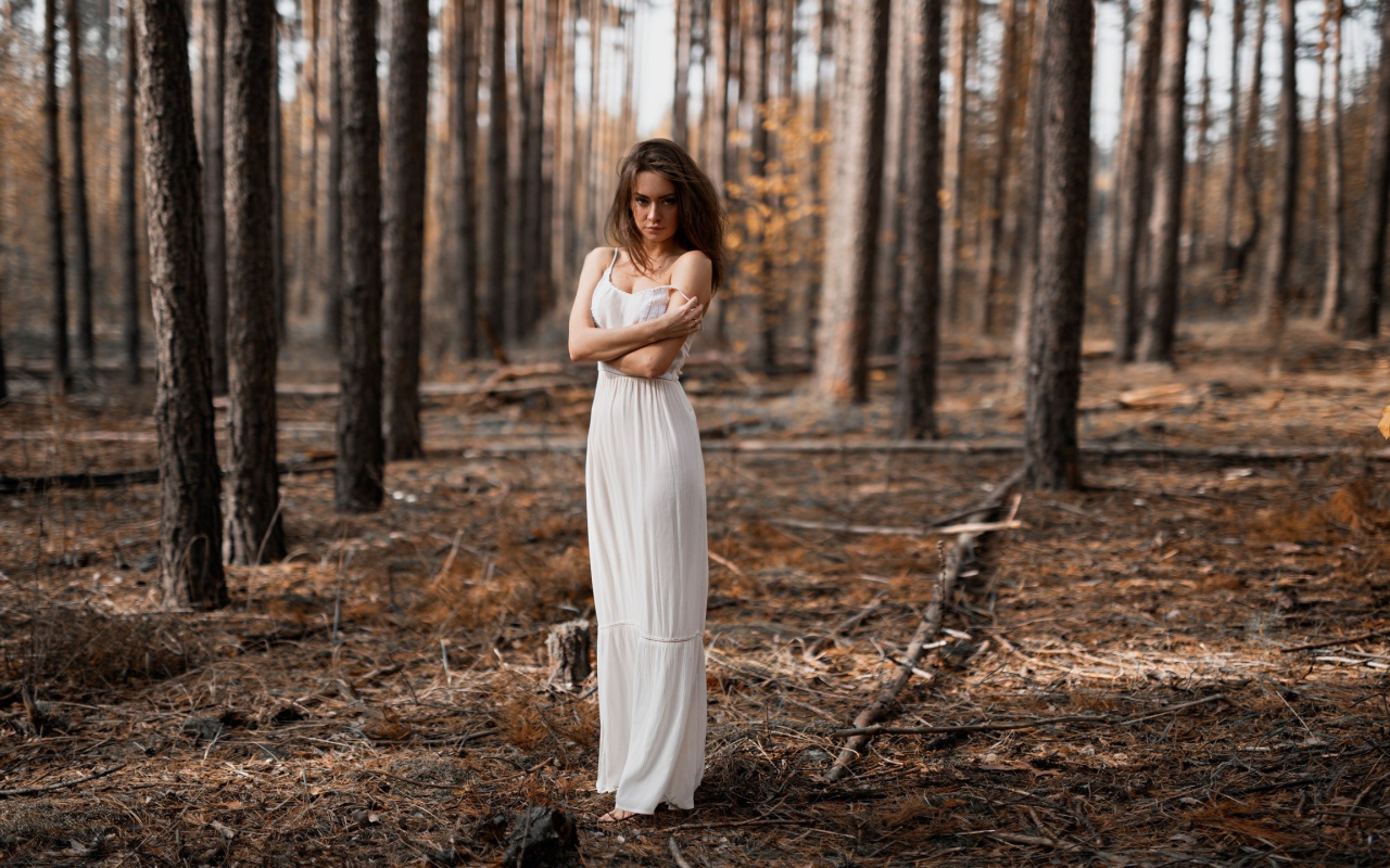 Молодая девушка в белом платье в лесу 
