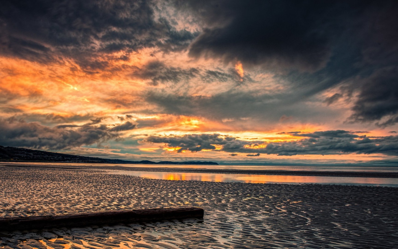 Прохладный закат в хмуром небе  над пляжем