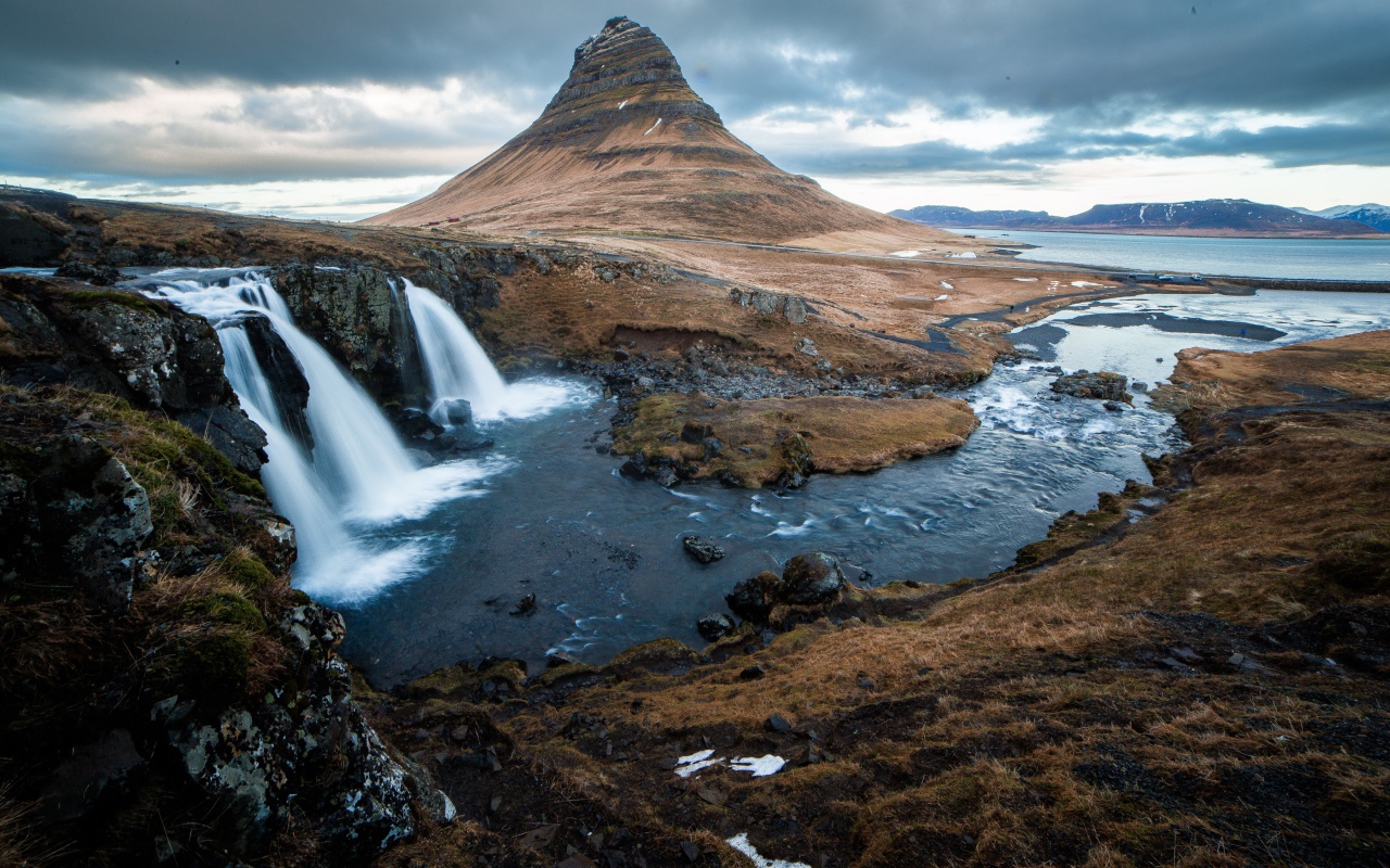 Гора и водопад у реки в Исландии  