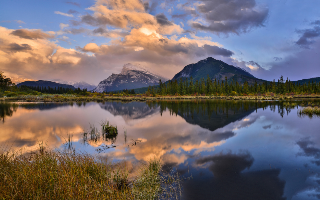 Небо и горы отражаются в чистой воде озера 