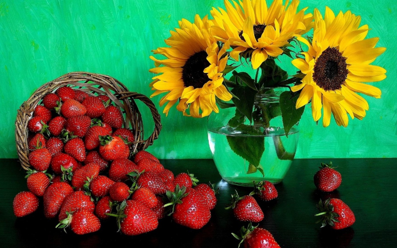Цветы желтого подсолнуха в вазе со свежей клубникой 