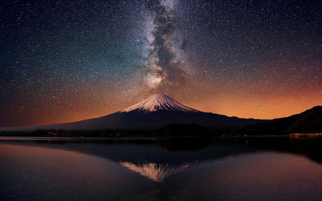 Заснеженная вершина горы на фоне млечного пути 