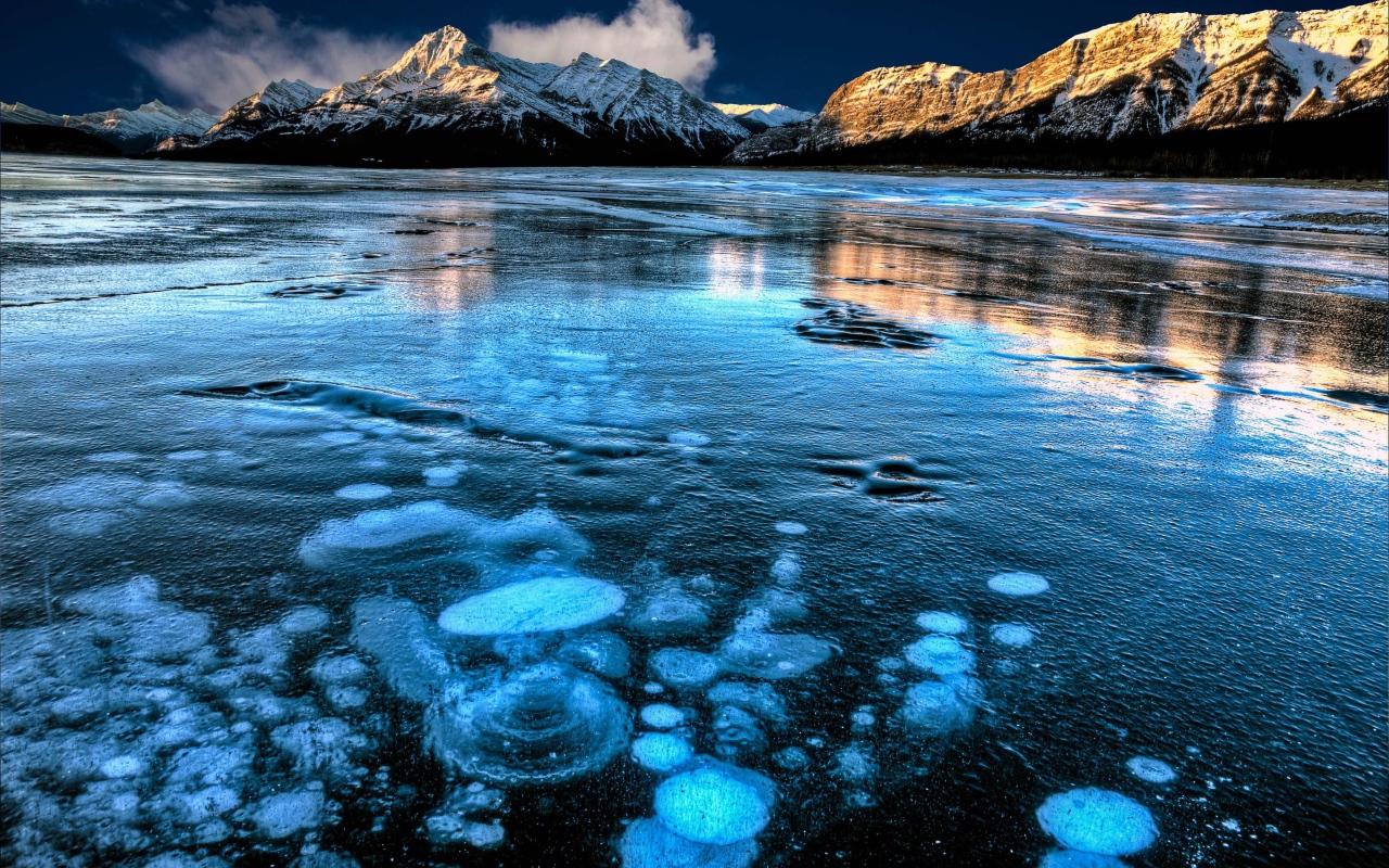 Покрытое льдом чистое  озеро Эйбрахам на фоне гор, Канада