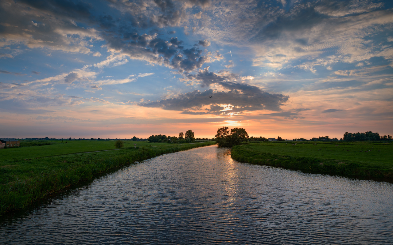 Закат солнца в облаках  над спокойной рекой