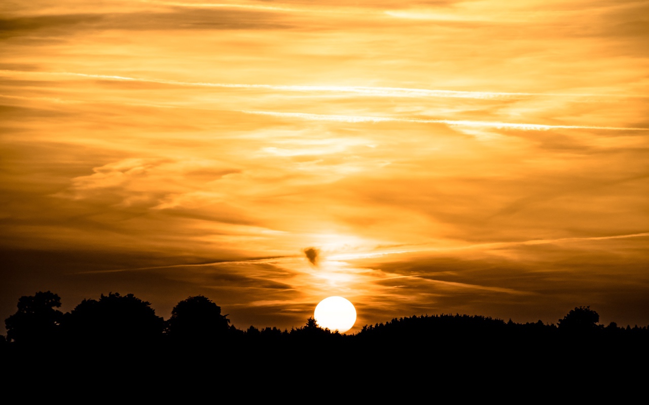 Закат солнца в небе золотого цвета