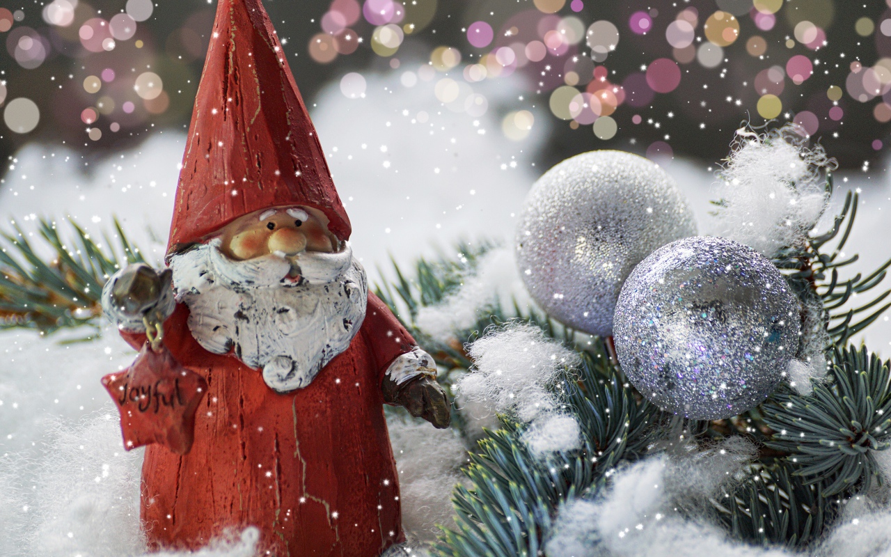 Figurine of Santa Claus near the spruce branch and bright balls