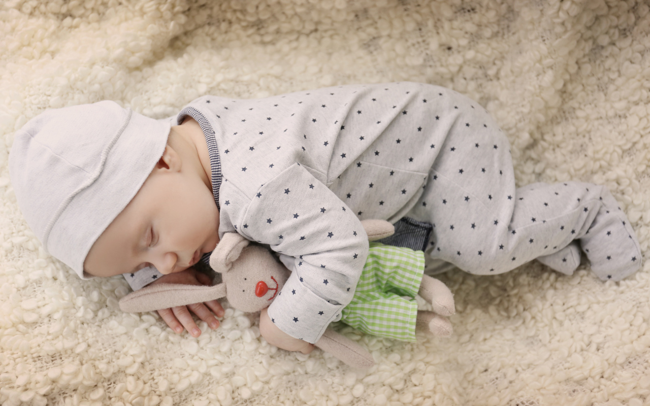 Грудной ребенок спит с любимой мягкой игрушкой