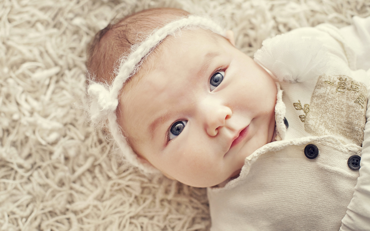 Красивая голубоглазая малышка с повязкой на голове