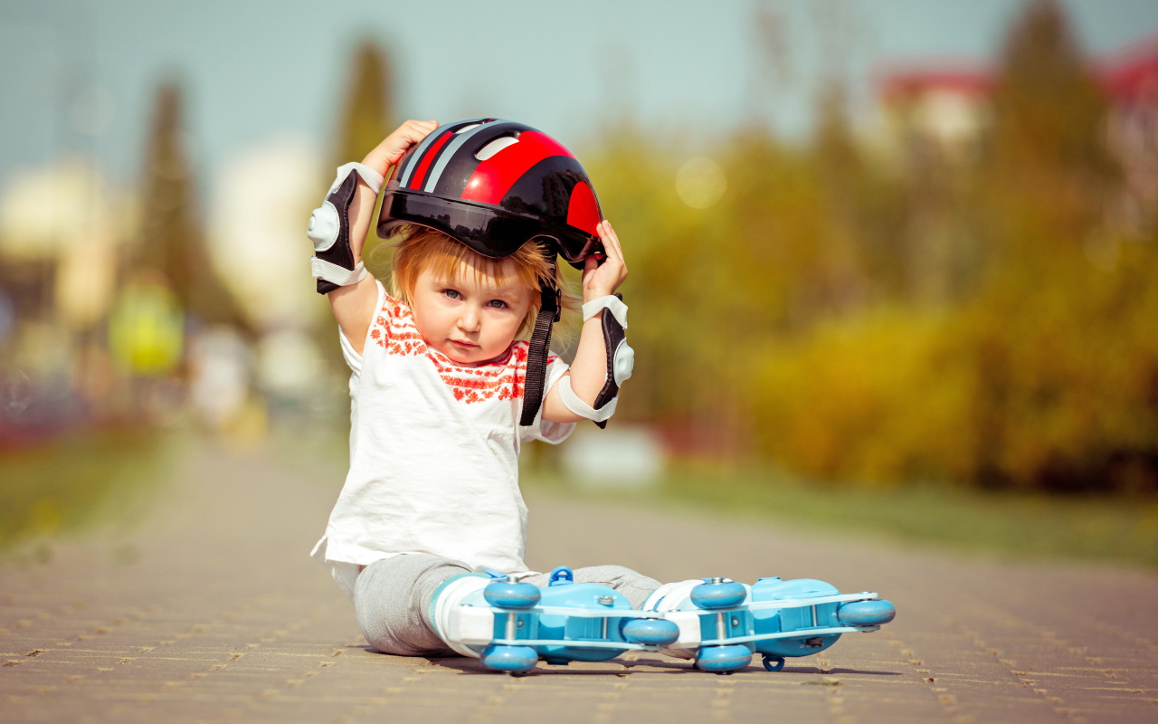 Маленький мальчик в шлеме и роликовых коньках