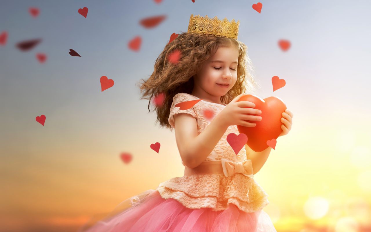 Маленькая девочка в костюме принцессы с красным сердцем в руках