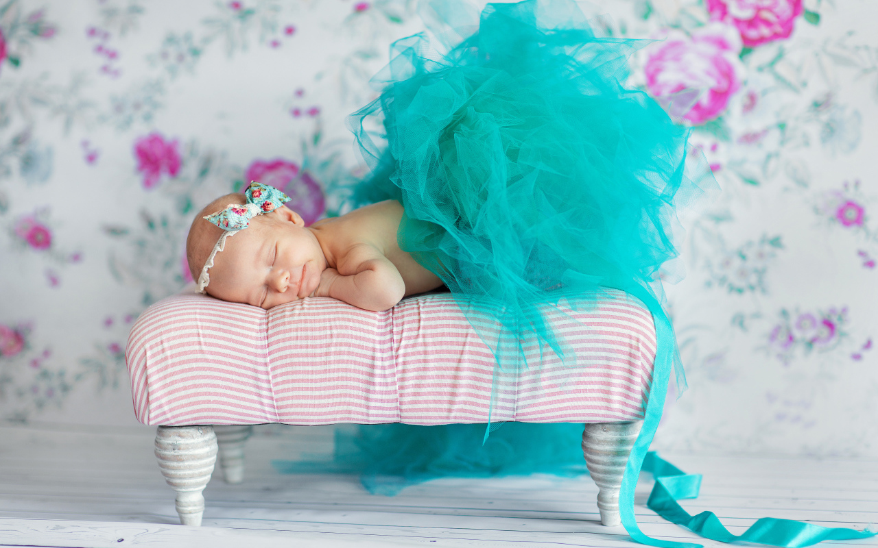 Маленькая девочка спит в красивом бирюзовом платье