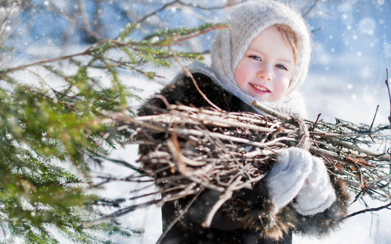 Маленькая девочка с пучком хвороста зимой