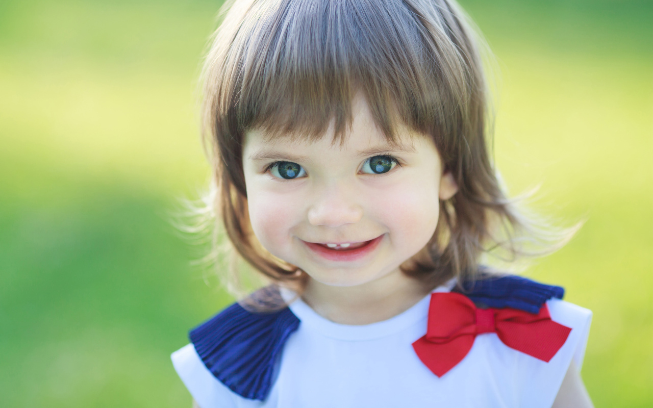 Милая улыбающаяся зеленоглазая маленькая девочка