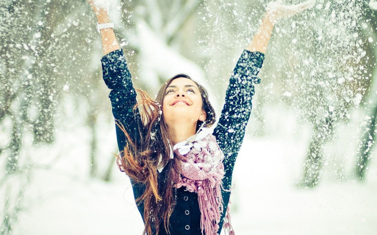 Красивая девушка радуется снегу 
