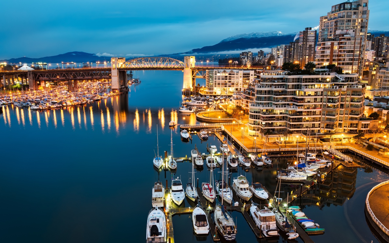 Лодки у причала на фоне ночных огней города Ванкувер, Канада