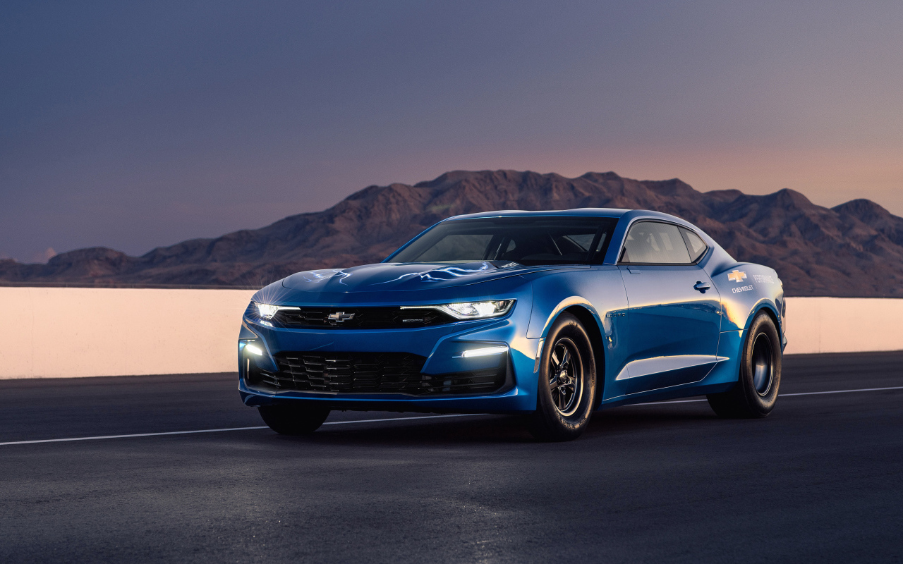 Синий автомобиль Chevrolet Camaro на трассе на фоне гор