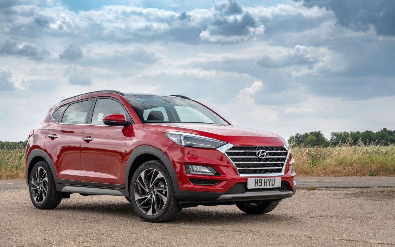 Красный автомобиль Hyundai Tucson, 2019 года под пасмурным небом