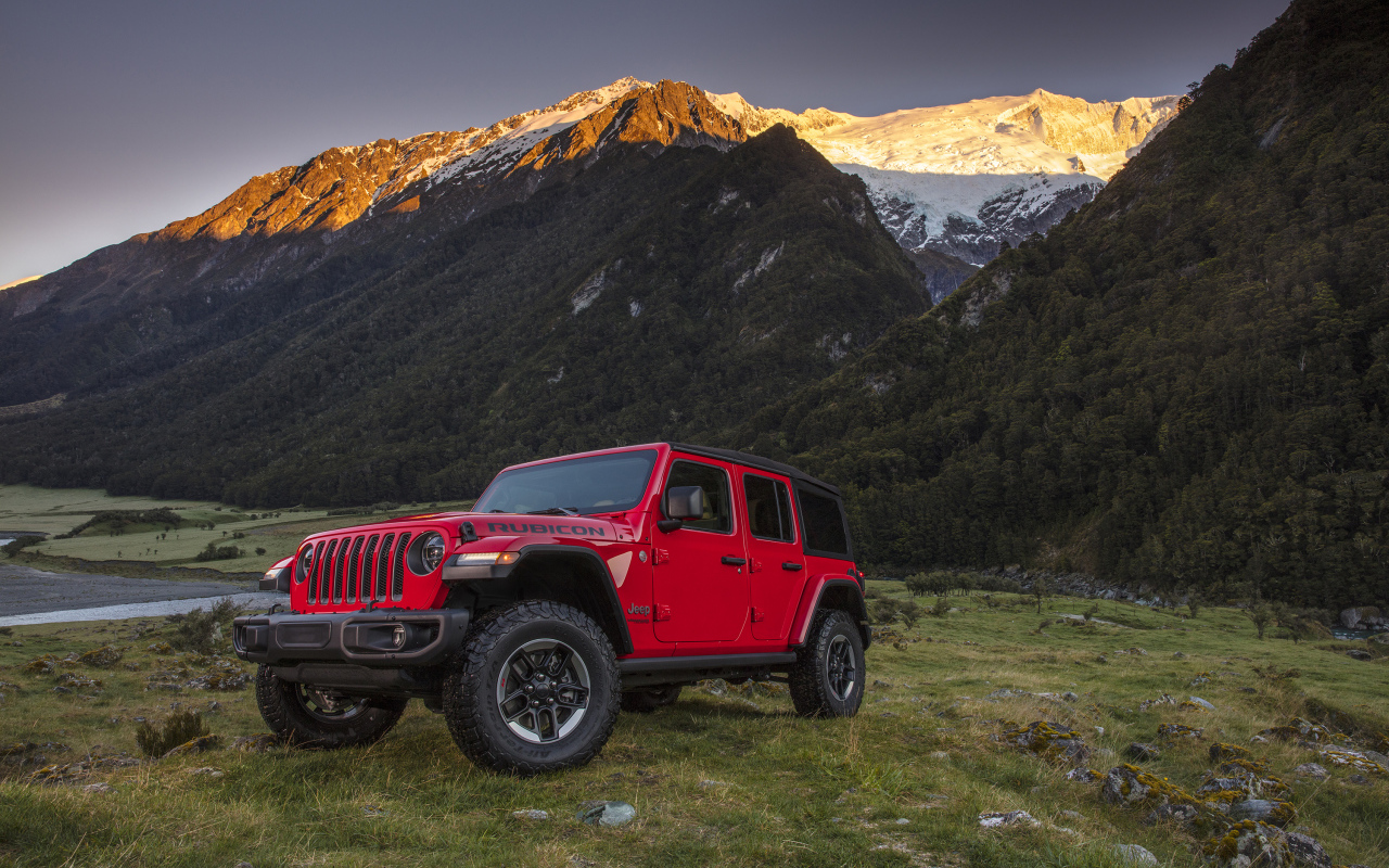 Красный автомобиль Jeep Wrangler на фоне гор