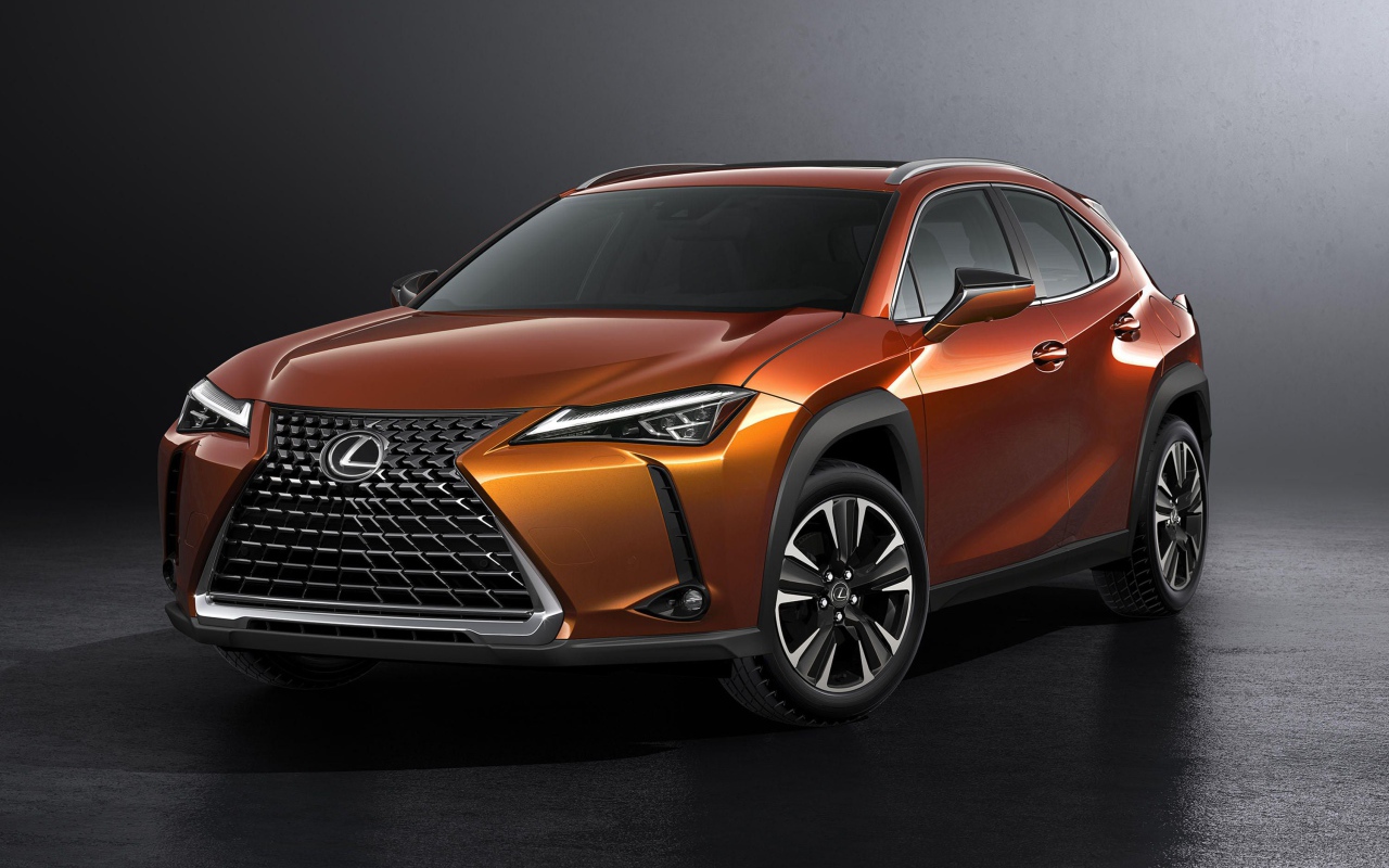 Оранжевый автомобиль Lexus UX, 2019 на сером фоне