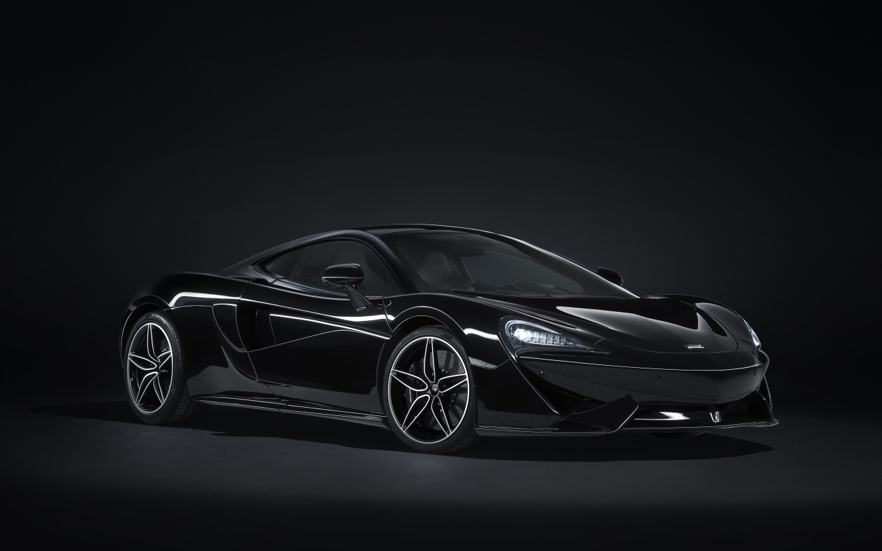Черный спортивный автомобиль McLaren 570GT на сером фоне