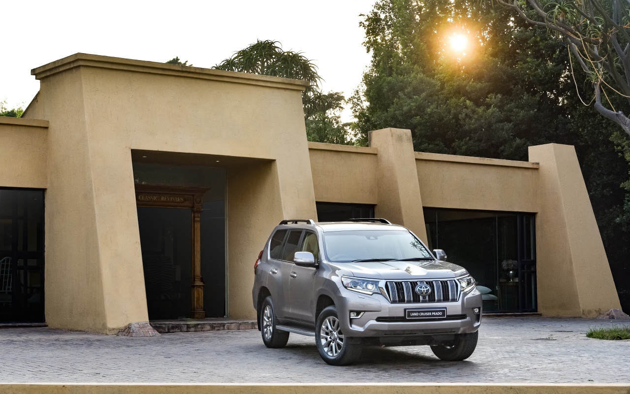 Серебристый внедорожник Toyota Land Cruiser Prado VX-L, 2018 года  в лучах солнца 