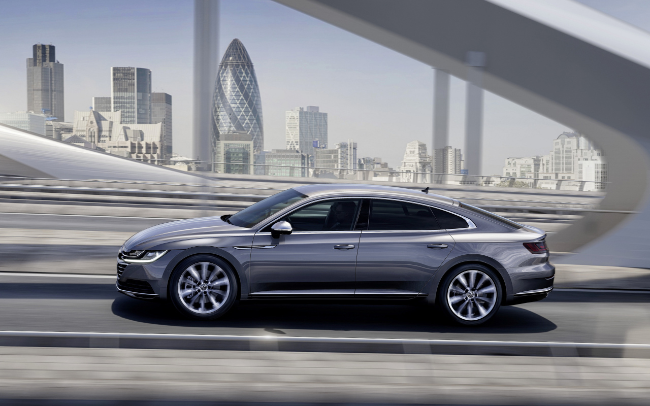 Серебристый автомобиль Volkswagen Arteon, 2018 года на фоне города