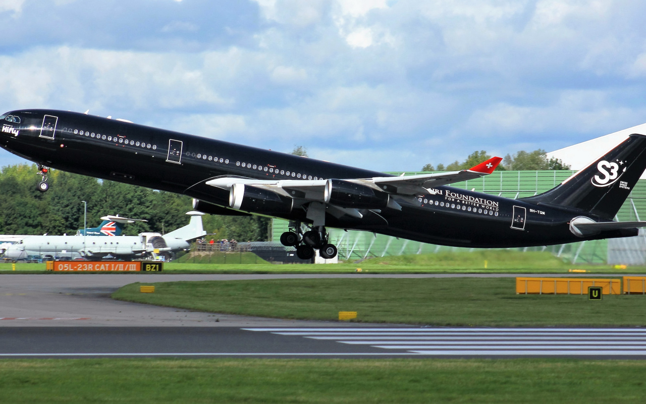 Black passenger airplane Airbus A340-313 on take-off