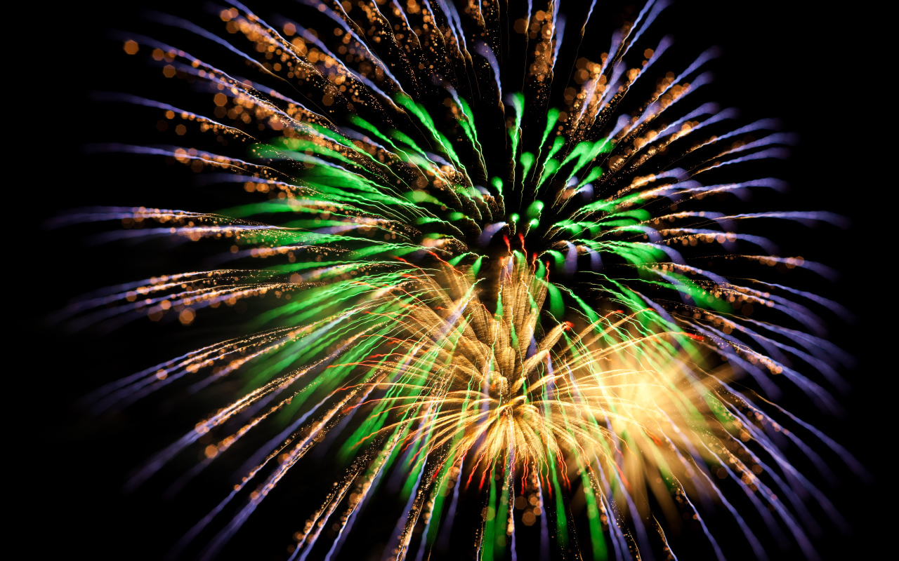 Красивые разноцветные искры праздничного салюта на черном фоне