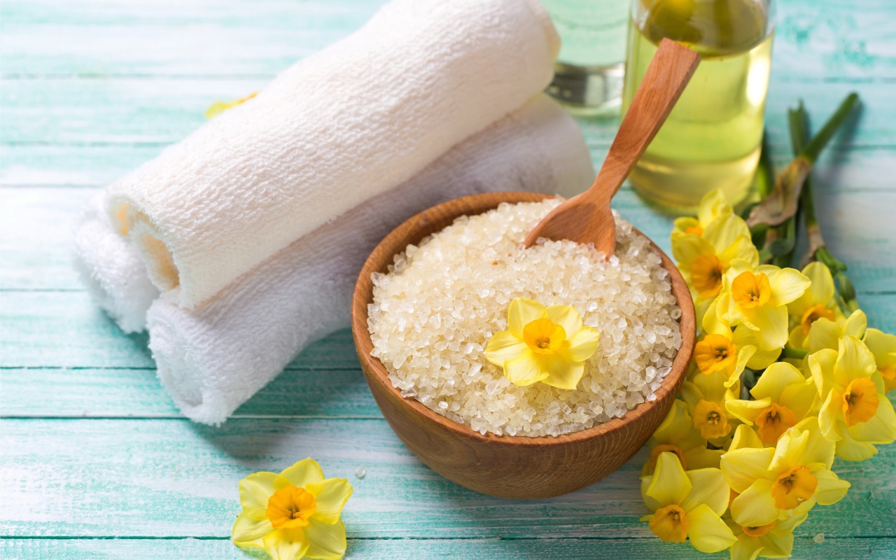 Соль с цветами нарцисса и полотенцем на столе